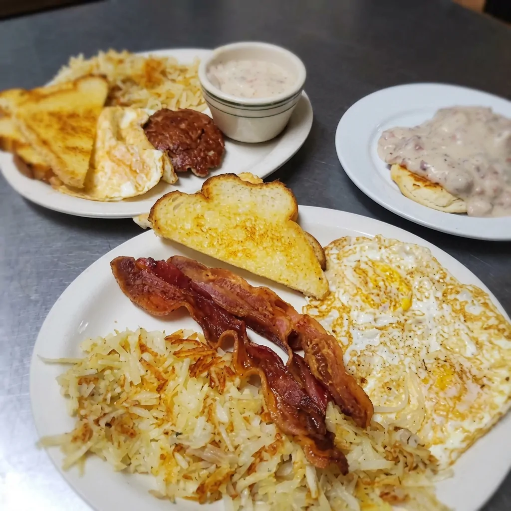 Eggs, bacon, hash browns and toast with biscuits and gravy