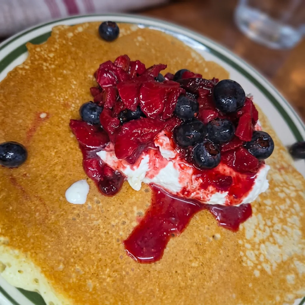 Pancake topped with berries and cream