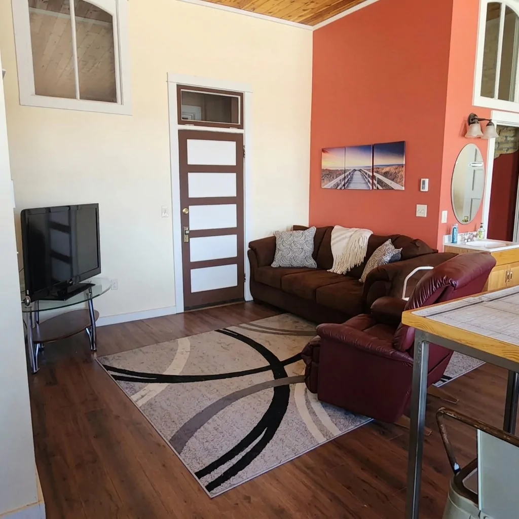 Studio sitting area with sofa, recliner and TV